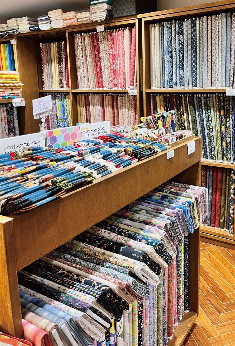 船場センター店の生地棚。moda のカットクロスや国内外のプリント生地が並ぶ